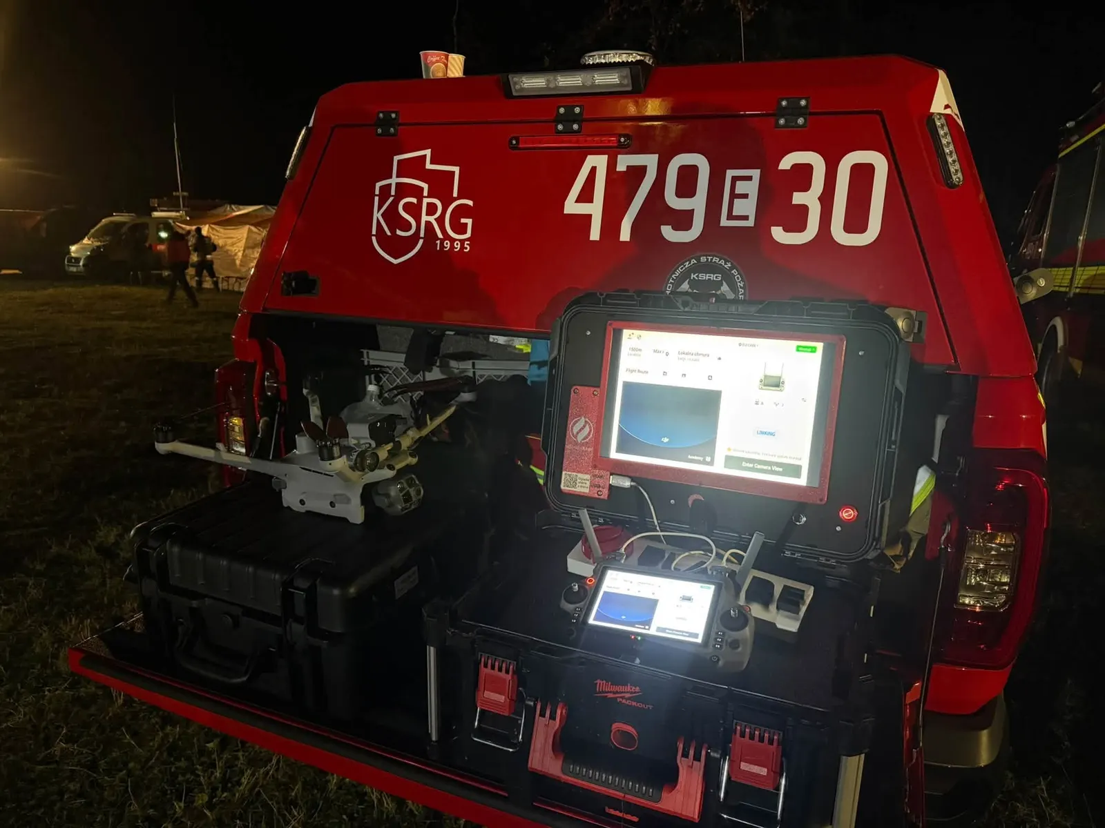 Stanowisko dronowe w wozie OSP na manewrach: dron, aparatura i tablet przed nocnym startem
